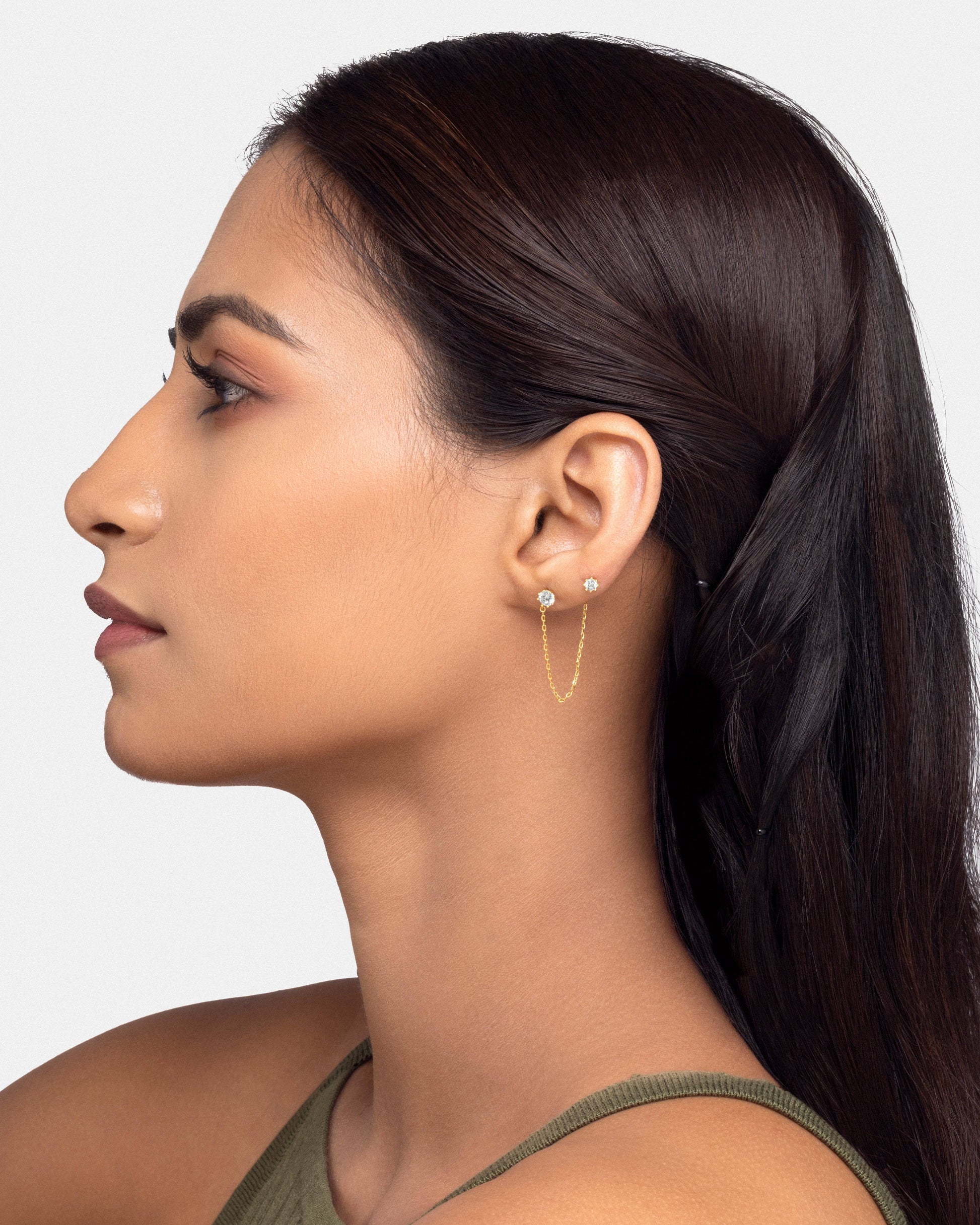 Side profile of a model displaying the Solitaire Chain Connector - 3-in-1 stud, emphasizing its versatile chain link between two solitaire studs.