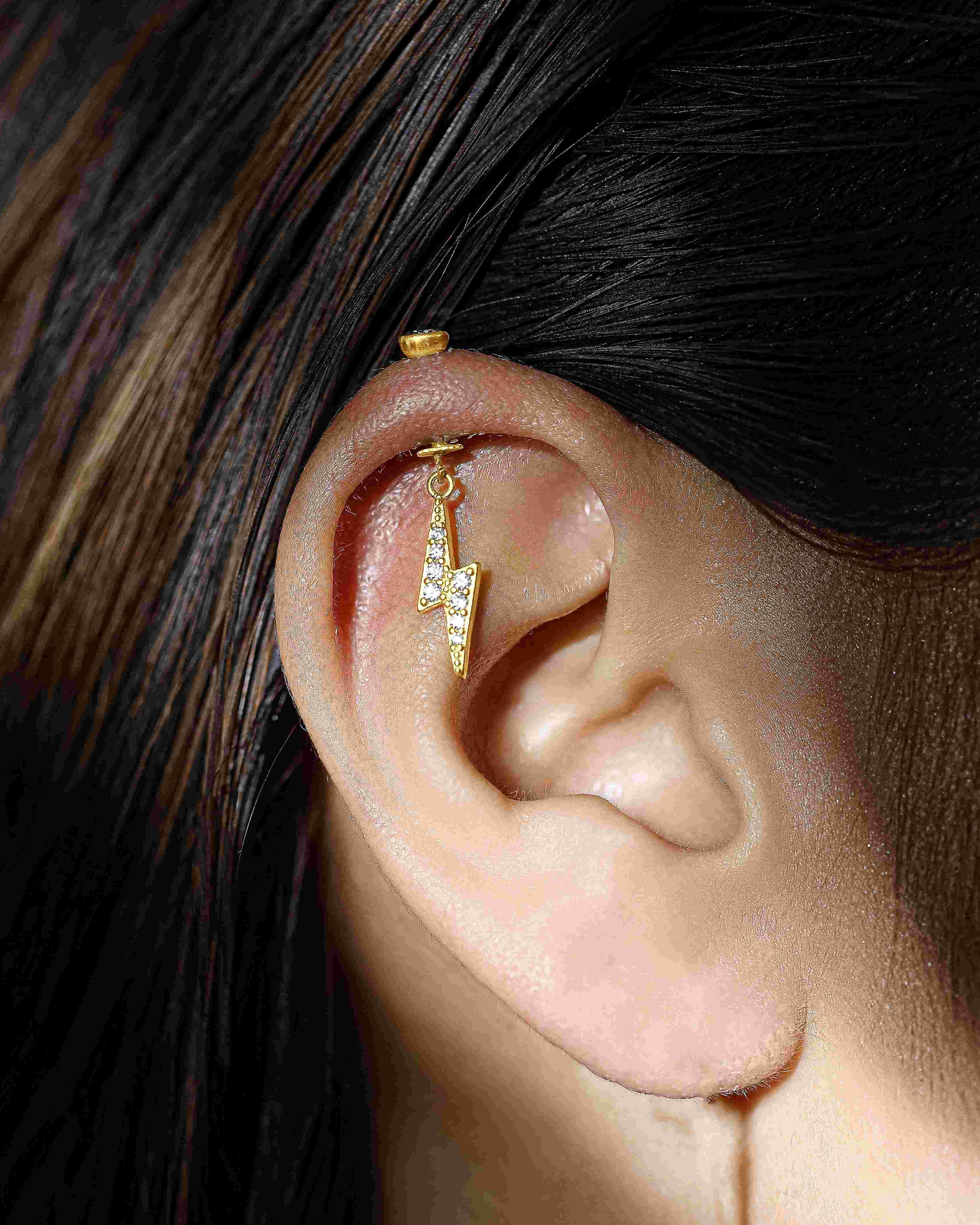 Thunder Helix Piercing - Zircon Screw Earrings worn on ear, showcasing stylish gold lightning design with sparkling zircon stones.