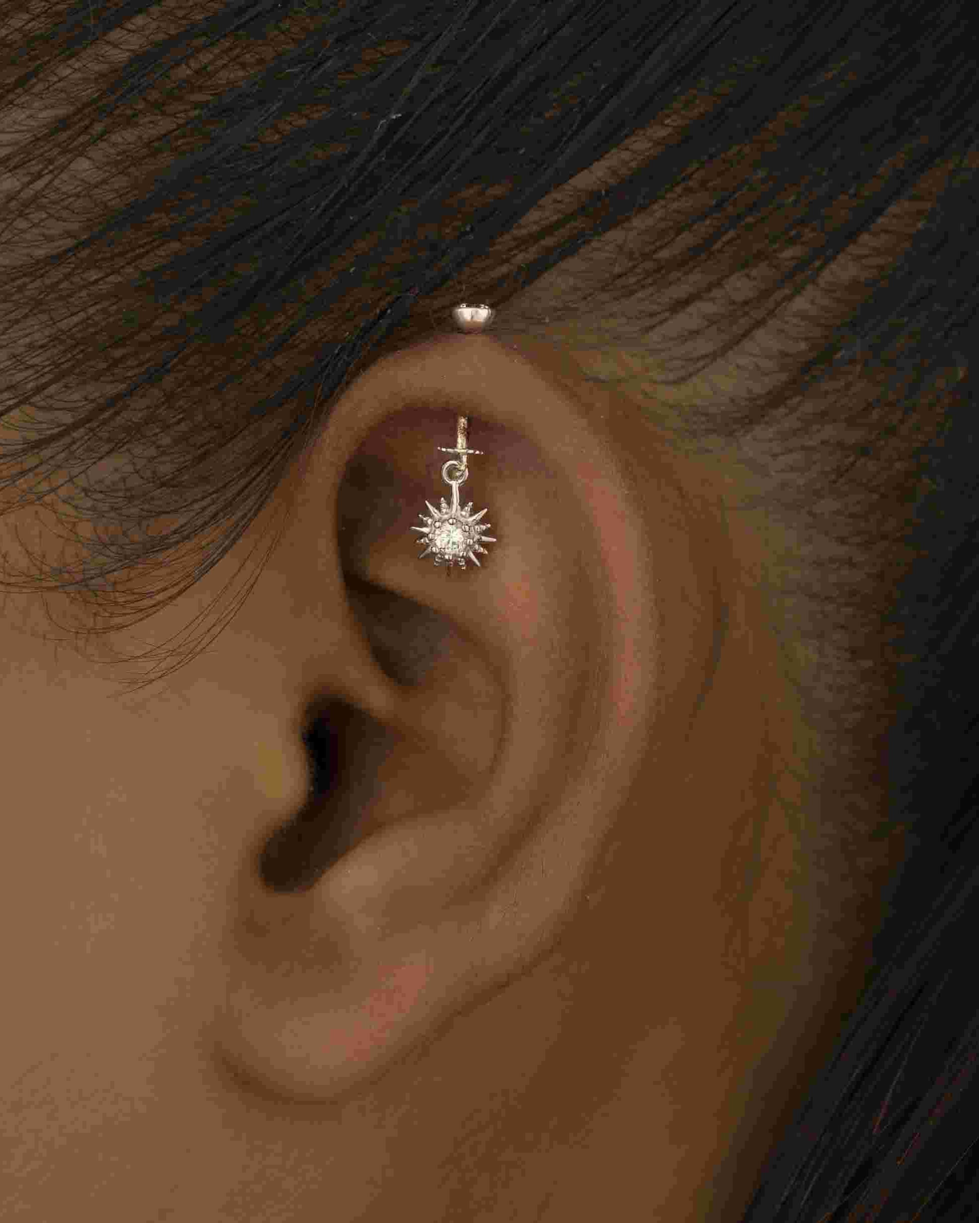 Glowing sunrays Helix Hanging earring worn on upper ear, showcasing eye-catching sunray design perfect for helix piercings and modern looks.